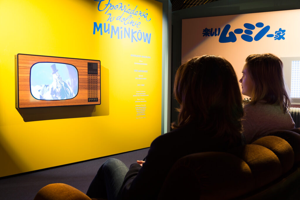 Two ladies watching animations on TV.