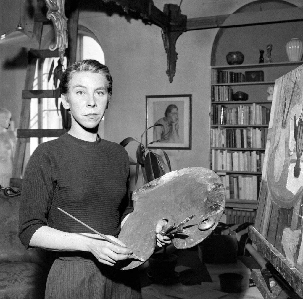 Mustavalkoinen valokuva, jossa nainen seisoo maalauspaletti kädessään.