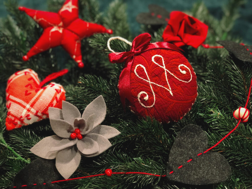 Kuusen oksilla punaisia kankaasta tehtyjä koristeita.